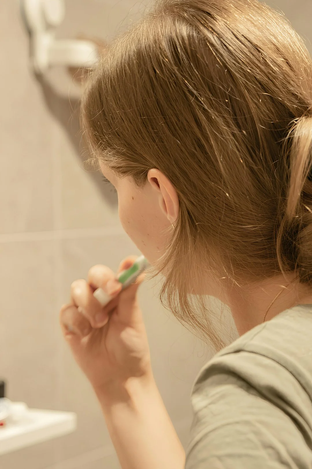 Personne utilisant un vaporisateur et un chiffon pour nettoyer une étagère de cuisine, en veillant à l’hygiène et à la propreté.