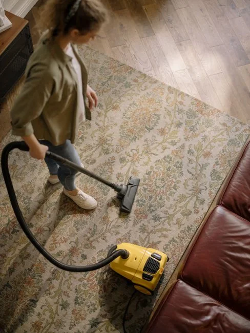 Sober room where a person is cleaning a chair with a sponge and a cleaning product.
